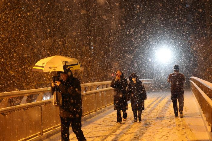 2月20日，北京市东直门南大街过街天桥，市民在雪中行走。新京报记者 王贵彬摄